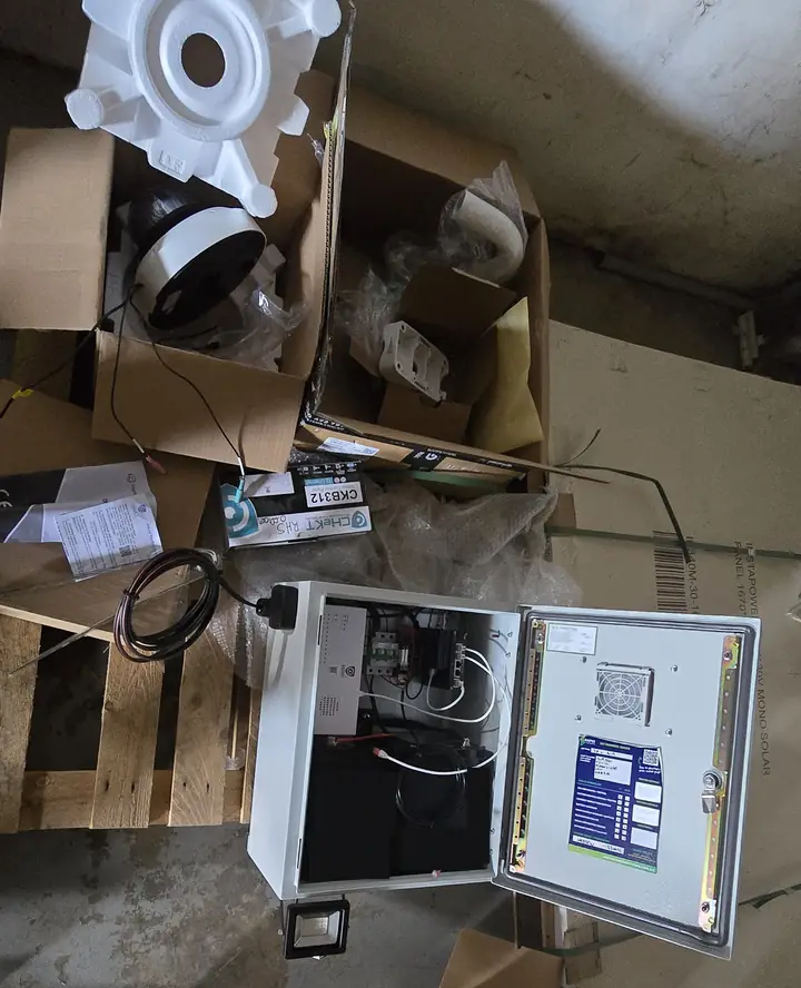 The control cabinet open on the bench, with its equipment wired up, next to the camera box