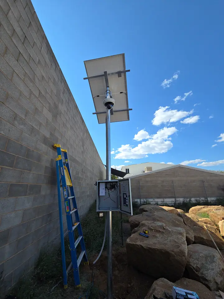 The finished pole with the camera under the solar panel and the cabinet below