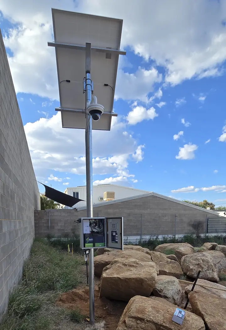 A solar-powered camera pole we fitted out: a Hanwha Wisenet PTZ camera under the solar panel, with the control cabinet on the pole