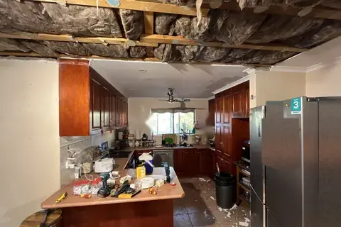 A home ceiling taken down to the roof frame with old insulation exposed, during a whole-home repair by Sawtell Contracting NT