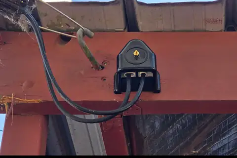 A weatherproof connection box on an outdoor beam, the kind of home electrical repair we do