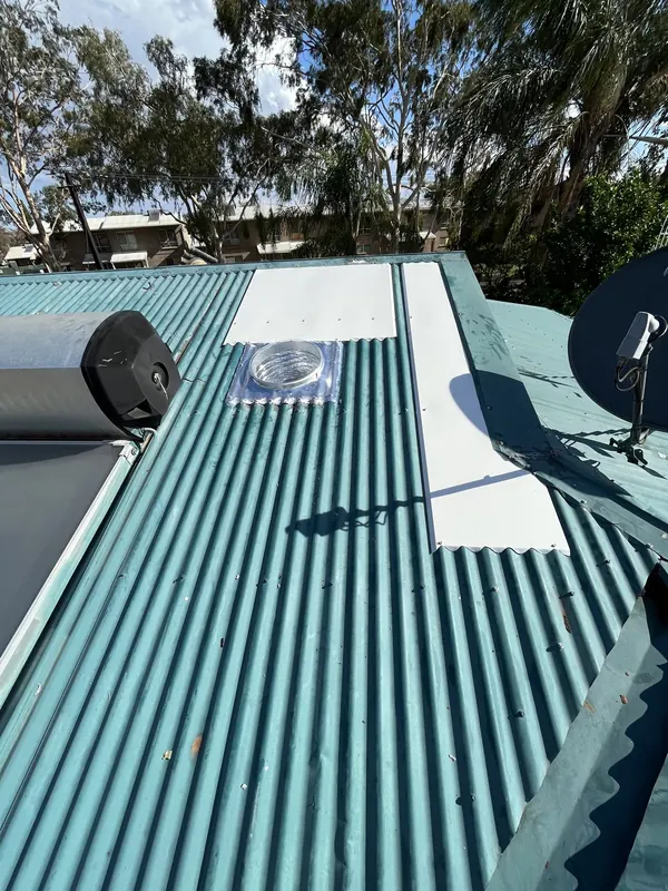 The repaired metal roof with a new skylight and new sheet metal, seen from the roof