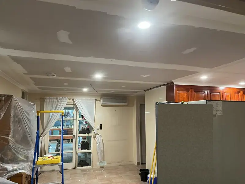 New ceiling sheets in the living area with patching compound on the joins, before painting